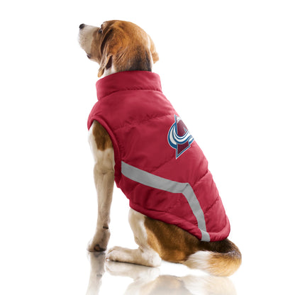 Dog wearing a red puffer vest with a logo on a white background