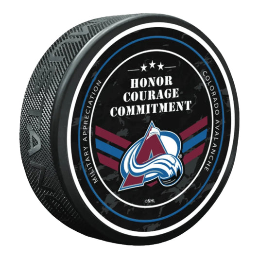 A black hockey puck featuring the Colorado Avalanche team logo and the words 'HONOR COURAGE COMMITMENT' on a clean white background.
