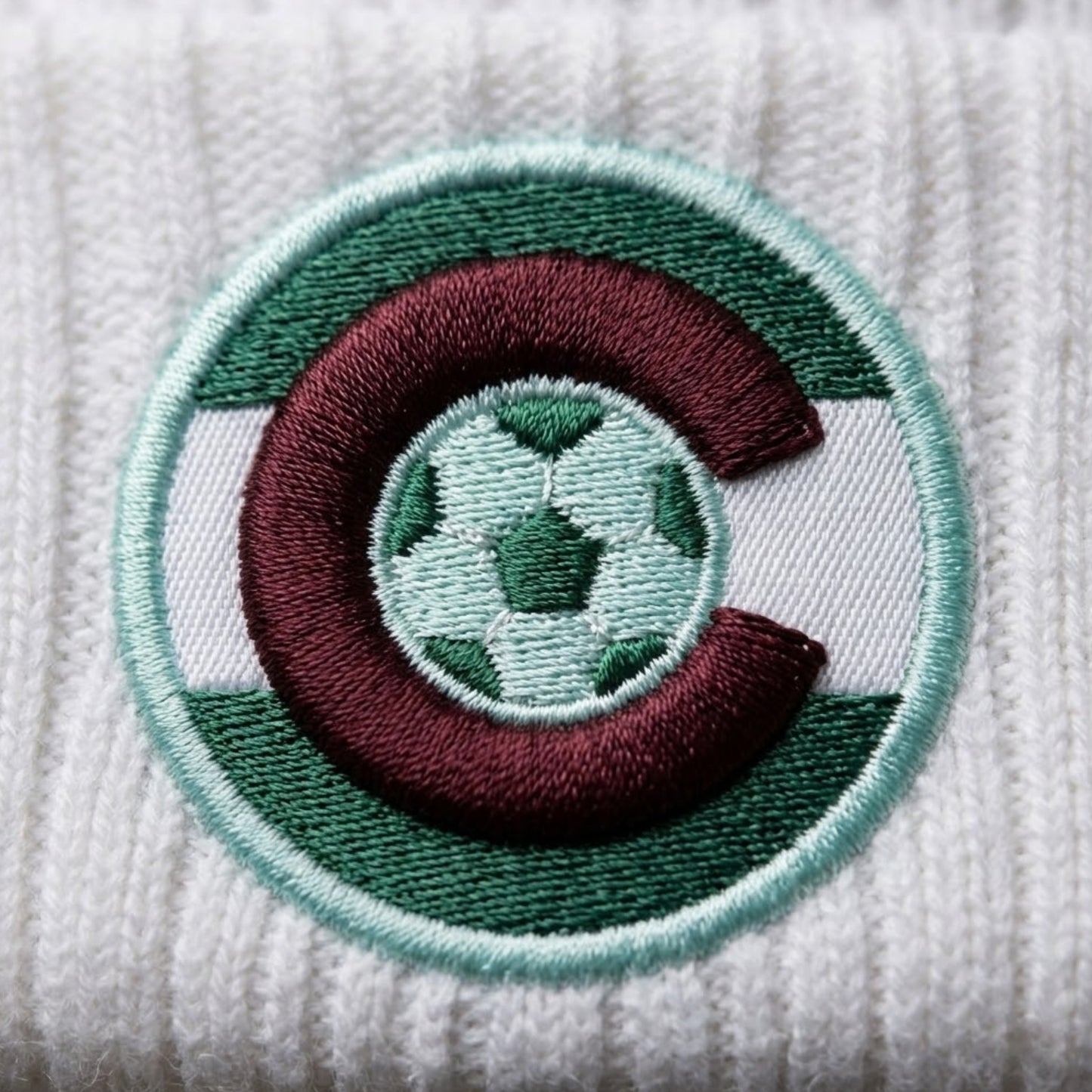 Embroidered patch with a soccer ball design on a textured white background
