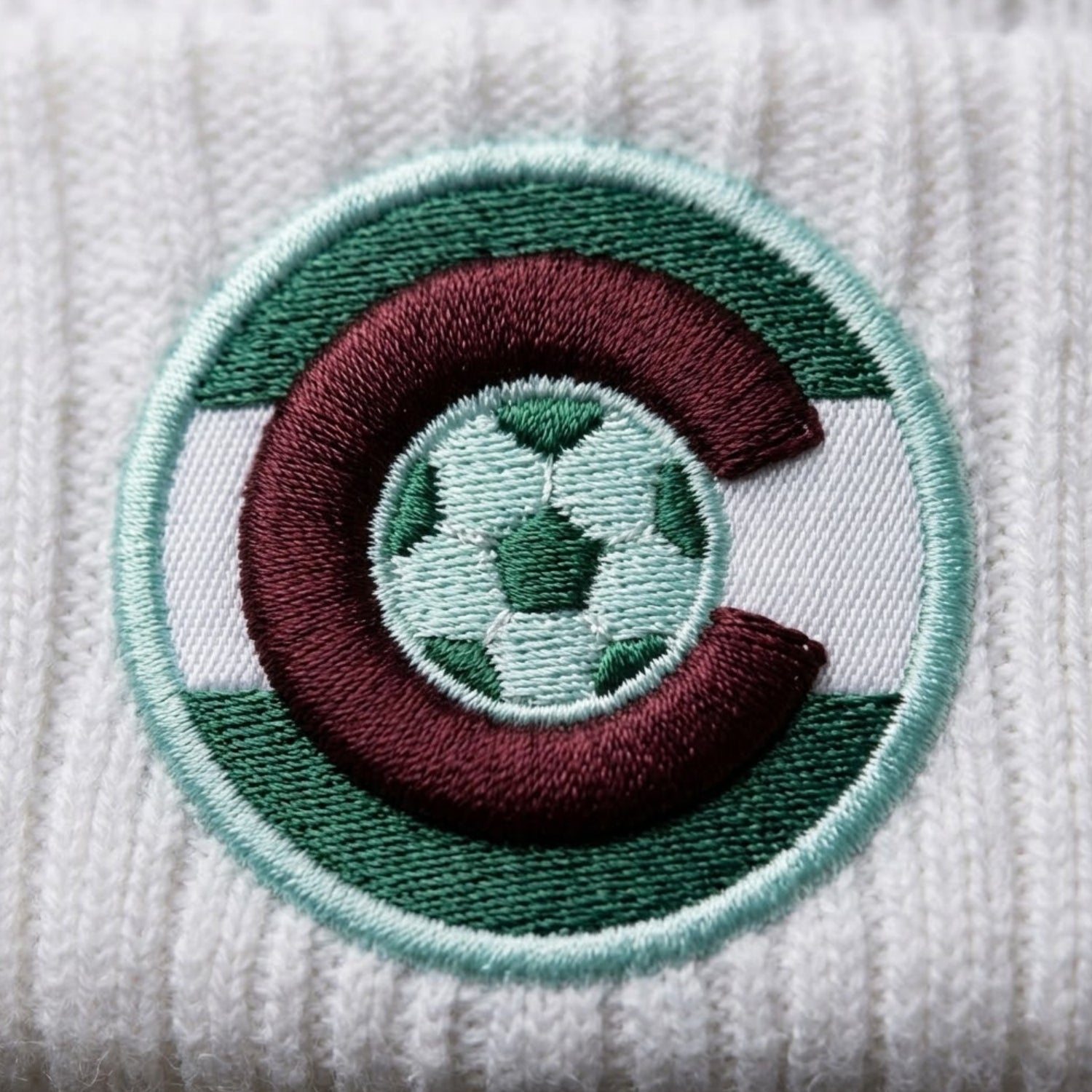 Embroidered patch with a soccer ball design on a textured white background