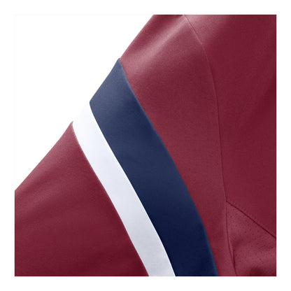 Close-up of a burgundy t-shirt sleeve featuring a diagonal navy blue stripe bordered by a white stripe.